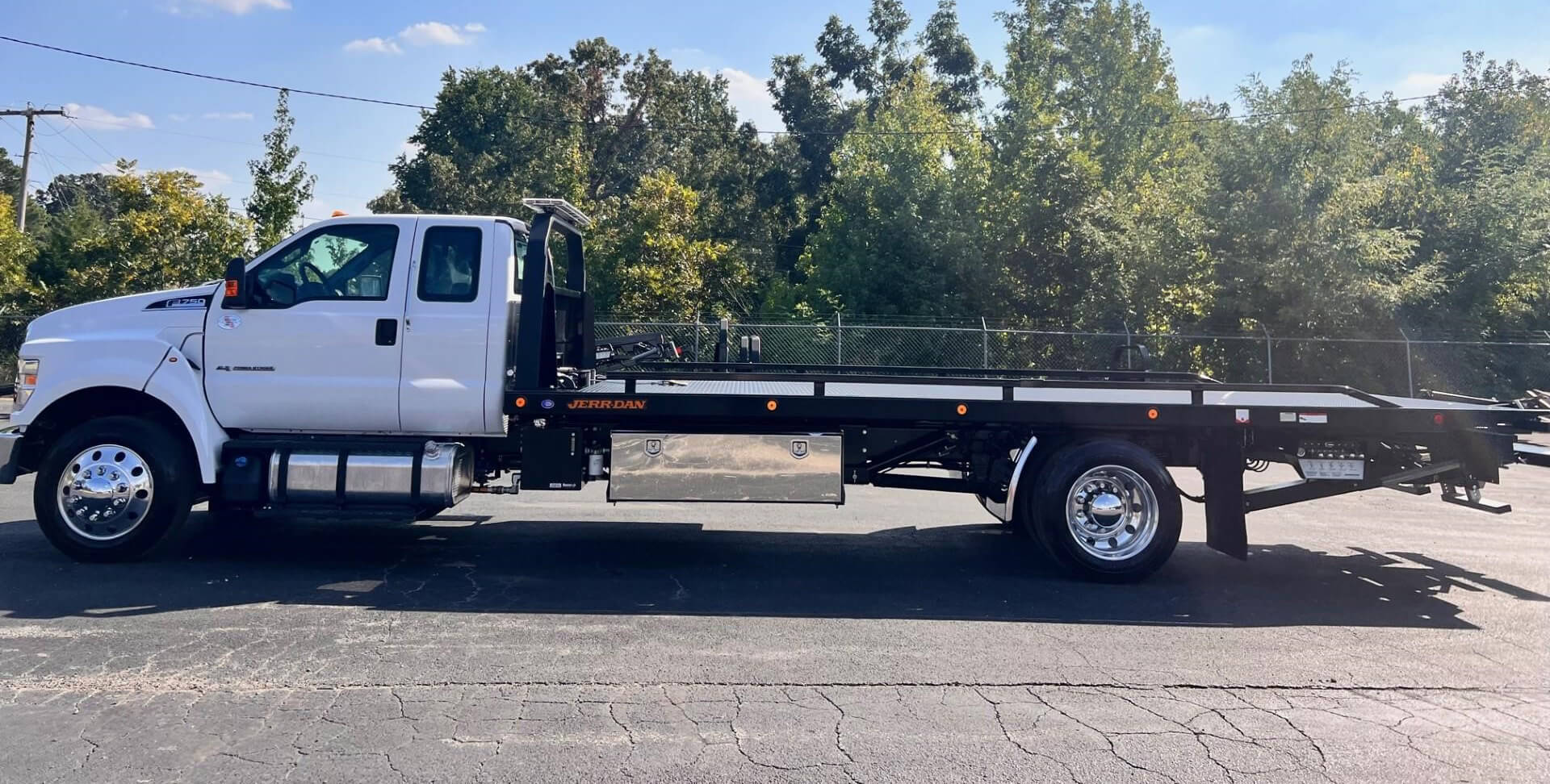 White trailer/truck in front of fence